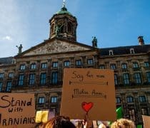 Hundreds Of People Are Seen Gathering While Holding Placards